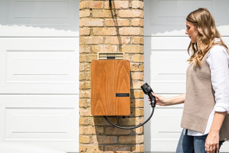 Homeowner plugging in a wall-mounted EV charger