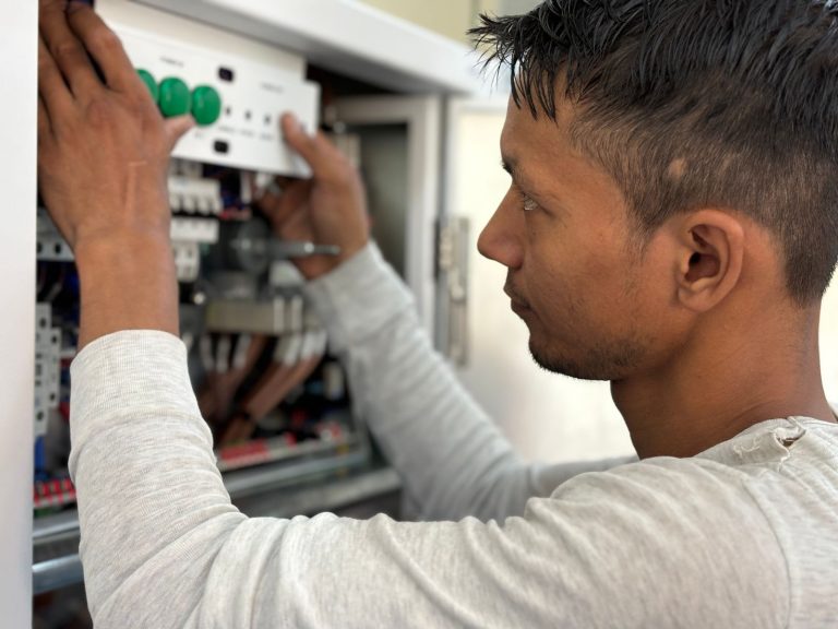 Electrician working inside a switchboard